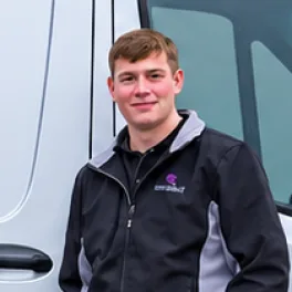 Theo Lodewijk, in zijn werkjas naast de bus.